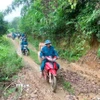 Hành trình chở lương thực, thực phẩm, nhu yếu phẩm bằng xe máy xuyên đại ngàn Pù Huống vào hỗ trợ cho bà con dân bản Na Ngân. (Ảnh: TTXVN phát)