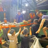 Ngư dân Trần Huy Biên được cán bộ chiến sĩ Đồn Biên phòng Quỳnh Thuận, Bộ đội Biên phòng Nghệ An, cứu hộ, đưa vào bờ cấp cứu an toàn. (Ảnh: TTXVN phát)