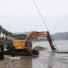 Thực hiện trục vớt chiếc xe tăng. (Ảnh: Sỹ Thắng/TTXVN)
