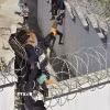 (Tư liệu) Người di cư trèo qua hàng rào biên giới để vào vùng lãnh thổ Ceuta của Tây Ban Nha từ thành phố Fnideq, Maroc. (Ảnh: THX/TTXVN phát)