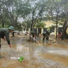 Các chiến sỹ Trung đoàn 6, Bộ Chỉ huy Quân sự thành phố Huế hỗ trợ nhân dân dọn dẹp vệ sinh sau mưa lũ. (Ảnh: Mai Trang/TTXVN)