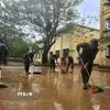 Các chiến sỹ Trung đoàn 6, Bộ Chỉ huy Quân sự thành phố Huế hỗ trợ nhân dân dọn dẹp vệ sinh sau mưa lũ. (Ảnh: Mai Trang/TTXVN)