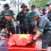 Thực hiện nghi thức phủ Quốc kỳ trang trọng, tri ân Anh hùng liệt sĩ đã hy sinh vì độc lập, tự do của Tổ quốc tại Nghĩa trang Mai Dịch (phường Phú Diễn). (Ảnh: Văn Điệp/TTXVN)
