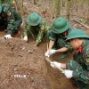 Lực lượng chức năng tìm kiếm quy tập hài cốt liệt sỹ. (Ảnh: TTXVN phát)