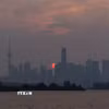 Khói từ các đám cháy rừng bao phủ bầu trời Toronto, Canada, ngày 16/7/2026. (Ảnh: THX/TTXVN phát)