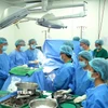 Các y bác sỹ mặc niệm tri ân người hiến tạng trước khi tiến hành lấy tạng. (Ảnh: TTXVN phát)