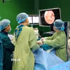 Các bác sỹ bệnh viện Đà Nẵng thực hiện phẫu thuật cho bệnh nhân bằng phương pháp nội soi cột sống hai cổng. (Ảnh: TTXVN phát)