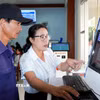 Hướng dẫn người dân tra cứu hồ sơ trực tuyến tại phường Nghĩa Lộ. (Ảnh: Lê Phước Ngọc/TTXVN)