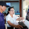 Hướng dẫn người dân tra cứu hồ sơ trực tuyến tại phường Nghĩa Lộ. (Ảnh: Lê Phước Ngọc/TTXVN)