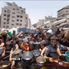Người dân nhận thức ăn cứu trợ tại Dải Gaza. (Ảnh: IRNA/TTXVN)