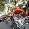 Du khách nước ngoài sử dụng xíchlô thưởng ngoạn nét đẹp cổ kính của Phố cổ Hà Nội. (Ảnh: Thanh Tùng/TTXVN)