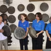 Ông Long giới thiệu những chiếc chiêng do mình sưu tầm với các đoàn viên thanh niên. (Ảnh: Đinh Hương/TTXVN)