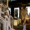 Khách du lịch đứng cạnh các hiện vật trưng bày tại Đại Bảo tàng Ai Cập - nơi sẽ chính thức mở cửa vào tháng 11/2025. (Ảnh: Reuters)