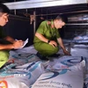 Lực lượng chức năng kiểm tra lô hàng đường trắng nghi nhập lậu vận chuyển trên 2 xe tải. (Ảnh: TTXVN phát0