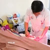 Bác sỹ kiểm tra vết thương của bệnh nhân bị đa tổn thương do pháo tự chế phát nổ gây ra. (Ảnh: Phan Sáu/TTXVN)