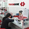 Hoạt động giao dịch tại Techcombank. (Ảnh: TTXVN)