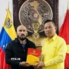 Đại sứ Việt Nam tại Venezuela tặng quà lưu niệm cho Giáo sư José Javier Díaz Macadan. (Ảnh: TTXVN phát)