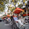 Du khách nước ngoài sử dụng xíchlô thưởng ngoạn nét đẹp cổ kính của Phố cổ Hà Nội. (Ảnh: Thanh Tùng/TTXVN)