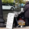 Một người vô gia cư với tấm biển cần giúp đỡ về tài chính trên một tuyến phố ở trung tâm thủ đô Washington D.C. (Ảnh: Ngọc Quang/TTXVN)