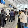 Người dân Trung Quốc làm thủ tục lên máy bay để về quê ăn Tết tại sân bay Đại Hưng - Bắc Kinh. (Ảnh: Công Tuyên/TTXVN)