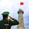 Chiến sỹ thực hiện nghi thức chào cờ tại Cột cờ A Pa Chải. (Ảnh: Xuân Tư/TTXVN)