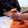 Người dân tộc Dao nắn xôi gấc xay nhuyễn trộn vừng rang để tạo hình và kích cỡ bánh giầy. (Ảnh: Thanh Hải/TTXVN)