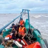 Hai ngư dân gặp nạn được tổ công tác Đồn Biên phòng Khánh Hội cứu đưa lên tàu an toàn. (Ảnh: TTXVN phát)