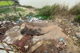 Chất thải rắn phát sinh từ quá trình phân tách kim loại bị đổ trực tiếp ra phía sau các xưởng, ven sông Đuống. (Ảnh: CAHN)