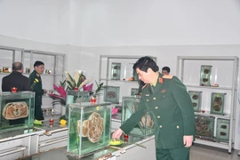 Trung tướng, Phó Giáo sư - Tiến sĩ Nghiêm Đức Thuận, Chính ủy Học viện Quân y đặt hoa tri ân tại phòng trưng bày, lưu trữ tiêu bản. (Ảnh: PV/Vietnam+)
