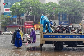 Cảnh sát giao thông Hà Nội hỗ trợ người dân di chuyển trong mưa ngập