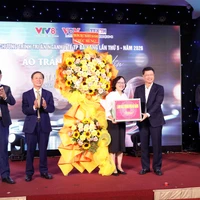 Ông Ngô Xuân Thắng, Phó Bí thư Thành ủy Đà Nẵng thay mặt lãnh đạo thành phố trao hoa chúc mừng đại diện ngành y tế và các đơn vị tổ chức. (Ảnh: Trần Lê Lâm/TTXVN)