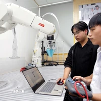 Sinh viên thực hành thử nghiệm các thuật toán điều khiển cánh tay robot tại phòng thí nghiệm Robotics, Trường Đại học Công nghiệp Thành phố Hồ Chí Minh. (Ảnh: Thanh Vũ/TTXVN)