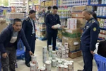 Lực lượng chức năng kiểm tra mặt hàng sữa. (Ảnh: PV/Vietnam+)