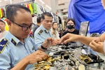 Cán bộ Cục Quản lý và Phát triển thị trường trong nước trực tiếp kiểm tra những "điểm nóng" về buôn lậu, hàng giả. (Ảnh: PV/Vietnam+)