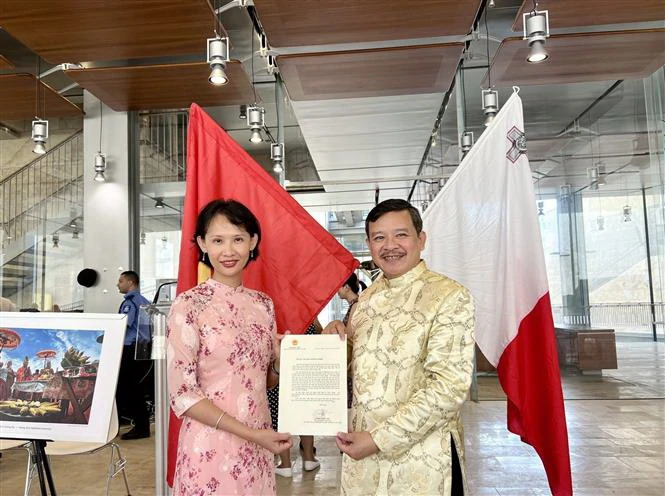 Đại diện Đại sứ quán Việt Nam tại Italy kiêm nhiệm Malta trao thư chúc mừng thành lập Hội người Việt Nam tại Malta của Thứ trưởng Ngoại giao Phạm Quang Hiệu cho Chủ tịch Hội Nguyễn Hoài Nam. (Ảnh: Dương Hoa/TTXVN)