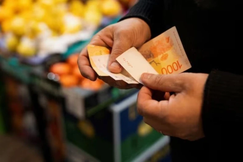 Kiểm tiền peso tại một khu chợ ở Buenos Aires (Argentina) ngày 11/5/2024. (Ảnh: Reuters/TTXVN)