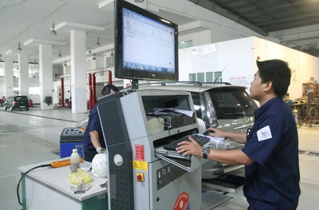 Đăng kiểm viên kiểm tra thông số kỹ thuật xe ôtô qua hệ thống máy tính. (Ảnh: Hoàng Hùng/TTXVN)