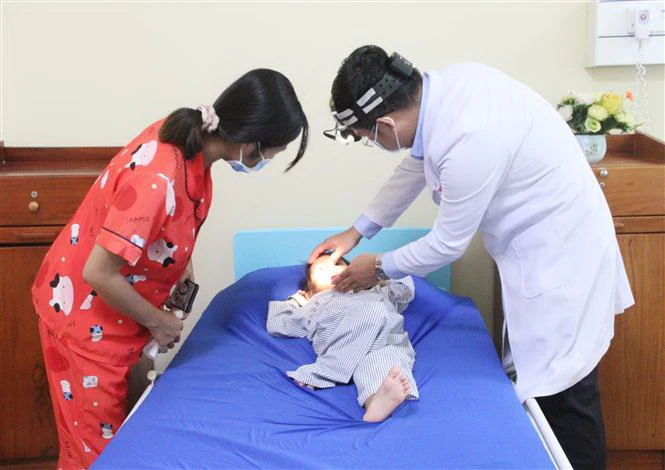 Bác sỹ hướng dẫn người nhà bệnh nhi cách chăm sóc mũi cho bé sau ca phẫu thuật. (Ảnh: Chanh Đa/TTXVN)