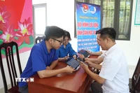Lực lượng đoàn thanh niên cơ sở tích cực hỗ trợ người dân thực hiện "Bình dân học vụ số". (Ảnh: Nguyễn Cúc/TTXVN)