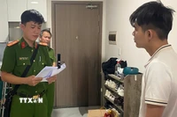 Cơ quan Cảnh sát điều tra đọc quyết định tạm giữ hình sự đối với Mai Minh Tấn. (Ảnh: TTXVN phát)