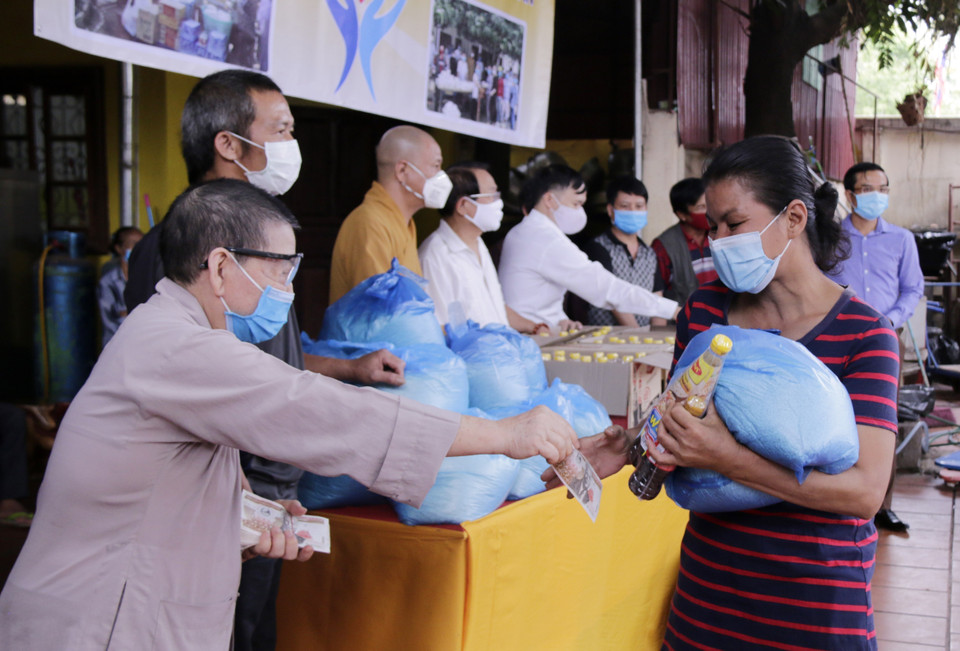 Các phật tử tại Chùa Phật Tích ở thủ đô Vientiane tổ chức trao 250 phần quà cho bà con người Việt gặp khó khăn trong thời gian Lào thực hiện các biện pháp giãn cách xã hội để ngăn chặn sự lây lan của dịch COVID-19 (24/4/2020). (Ảnh: Phạm Kiên/TTXVN)