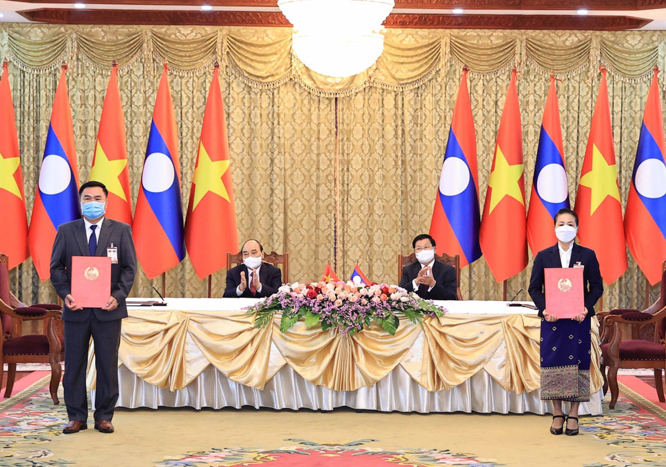 Chủ tịch nước Nguyễn Xuân Phúc và Tổng Bí thư, Chủ tịch nước Lào Thongloun Sisoulith chứng lễ ký kết văn kiện hợp tác giữa các Bộ, ngành và doanh nghiệp 2 nước trong chuyến thăm chính thức Lào (9/8/2021). (Ảnh: Thống Nhất/TTXVN)