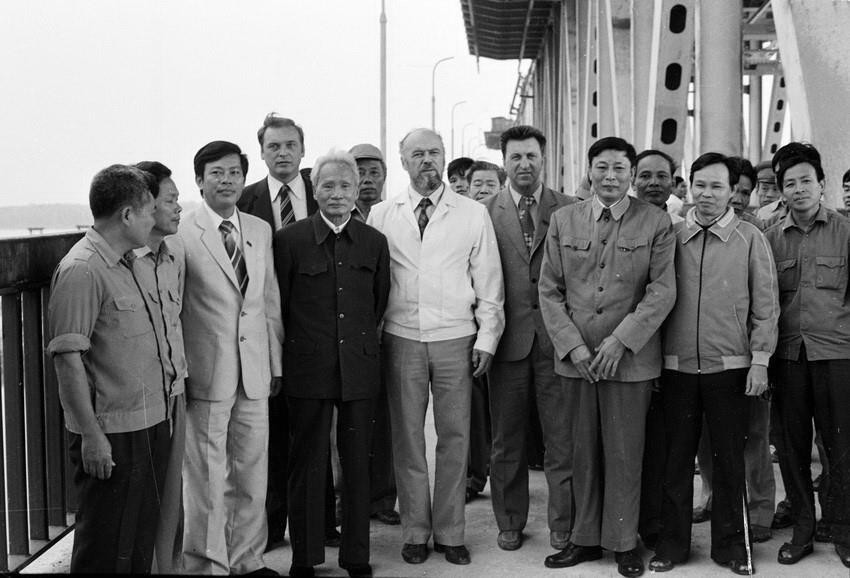 Bộ trưởng Bộ Giao thông vận tải Đồng Sỹ Nguyên (thứ ba từ phải sang) cùng các chuyên gia Liên Xô và công nhân Việt Nam đón Chủ tịch Hội đồng Bộ trưởng Phạm Văn Đồng đến thăm công trường xây dựng cầu Thăng Long, ngày 5/11/1983. (Ảnh: Xuân Lâm/TTXVN)