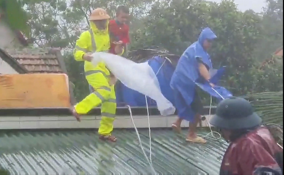 Lực lượng cứu nạn đưa người dân ra khỏi vùng lũ. (Ảnh: TTXVN)