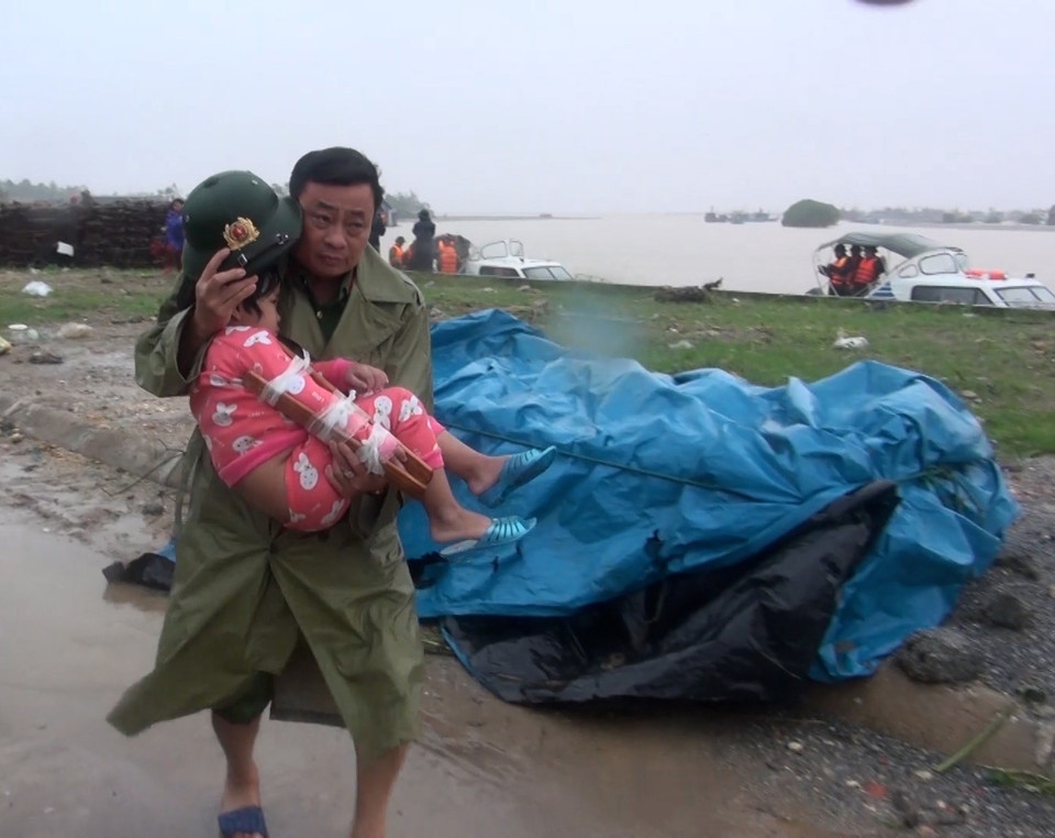 Lực lượng cứu nạn đưa người dân ra khỏi vùng lũ. (Ảnh: TTXVN)