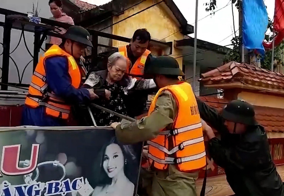 Lực lượng cứu nạn đưa người dân ra khỏi vùng lũ. (Ảnh: TTXVN)