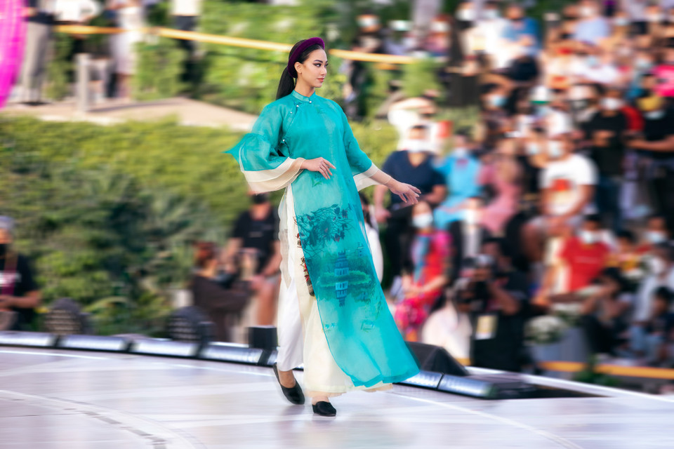 Mở màn cho đêm diễn là bộ sưu tập thời trang Áo dài tơ tằm ‘Những giấc mơ’ của nhà thiết kế Vũ Việt Hà. Á hậu Kim Duyên (Miss Universe Vietnam 2021) xuất hiện rạng ngời trong vai trò mở màn. Kim Duyên nhận được nhiều sự chú ý, trở thành tâm điểm của của truyền thông khi lần đầu tiên tham gia trình diễn thời trang sau khi khép lại hành trình ở Miss Universe 2021. (Ảnh: CTV/Vietnam+)