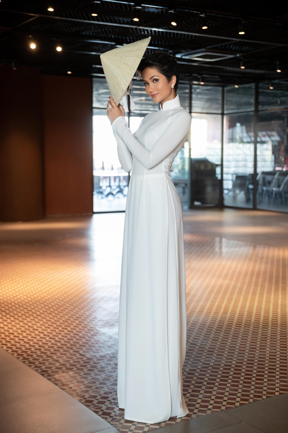 Có mặt tại sự kiện khá sớm, H’Hen Niê và êkíp ngẫu hứng chụp bộ ảnh áo dài trong khung cảnh nắng chiều tà, tận dụng bối cảnh ngay tại chương trình. (Ảnh: Thiên An/Vietnam+)