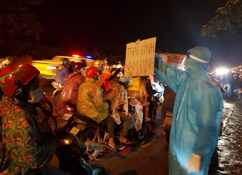 Do tình hình dịch bệnh tiếp tục có những diễn biến phức tạp, nhiều người dân đang sinh sống tại các tỉnh phía Nam đã đi xe máy trở về quê nhà ở các tỉnh phía Bắc. Lực lượng chức năng tỉnh Ninh Bình hỗ trợ công dân đi qua địa bàn. (Ảnh: Đức Phương/TTXVN)