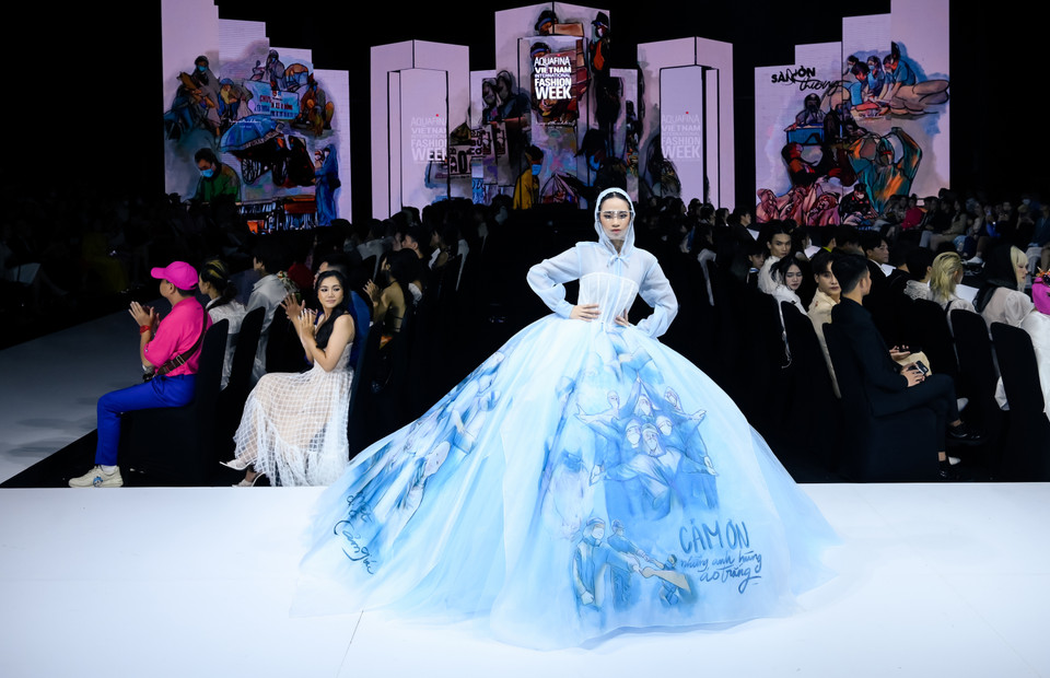 Bộ sưu tập với các thiết kế mở đầu lấy cảm hứng kết hợp từ đồ bảo hộ cùng màu áo trắng của các y bác sĩ, được xem là quyết định đầy mạo hiểm với Nguyễn Minh Công khi sử dụng duy nhất gam màu trắng-xanh trung tính để lột tả sự đổi mới cho từng trang phục. (Ảnh: CTV/Vietnam+)